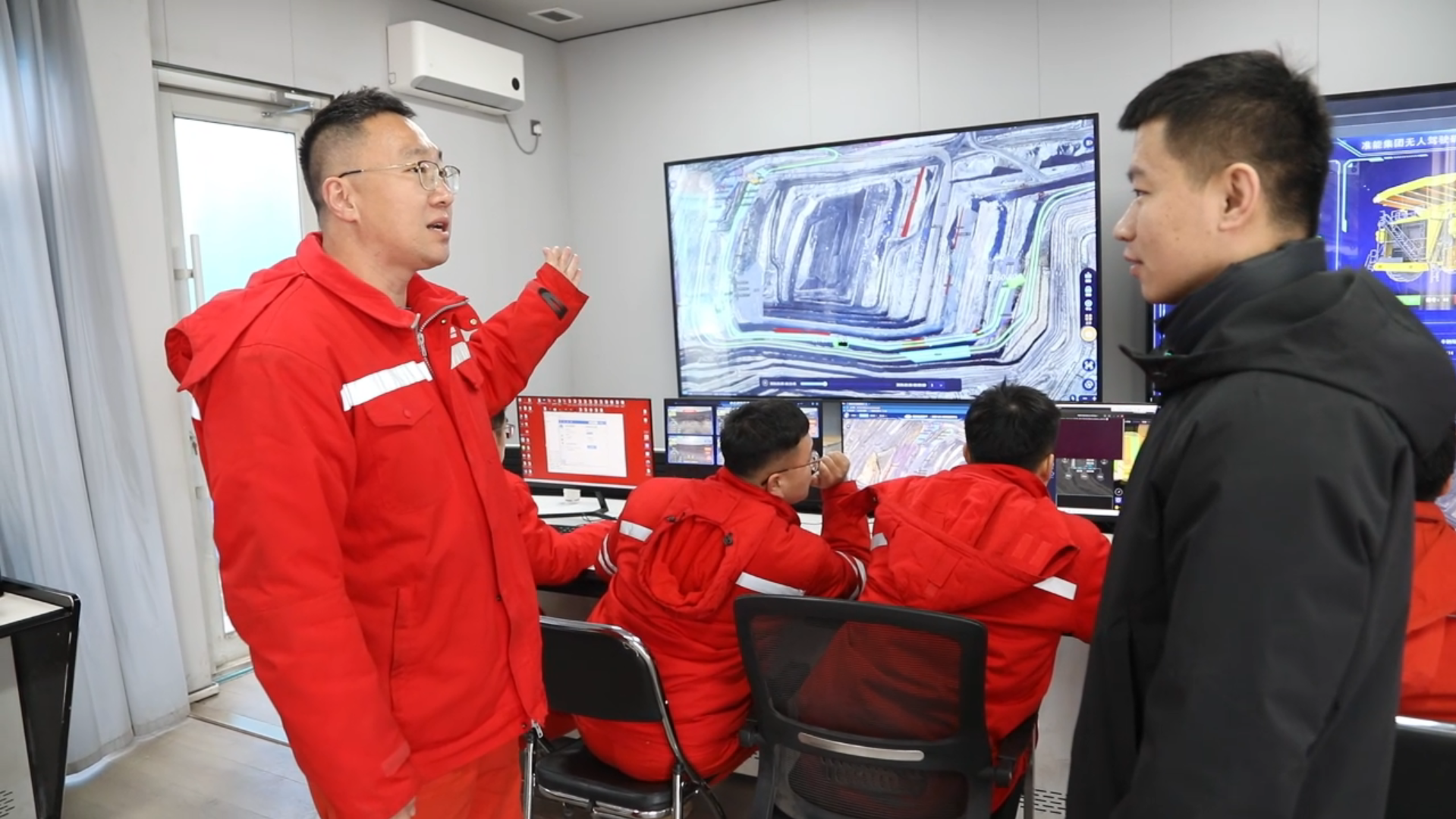 图为刘浩田向记者介绍无人驾驶矿卡运行情况.png